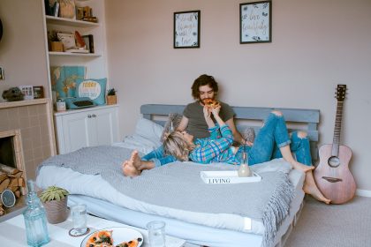 A man and a woman chilling on a bed