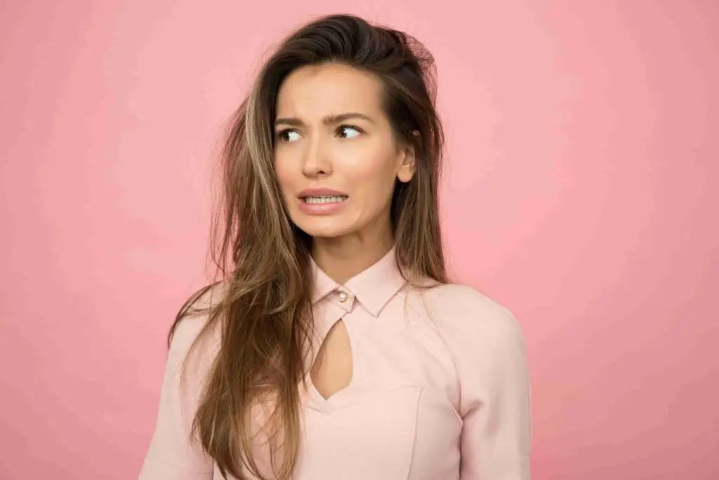 A woman wearing a pink blouse is surprised 