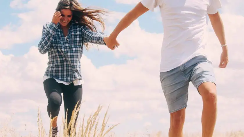 A man holding a woman hand while walking