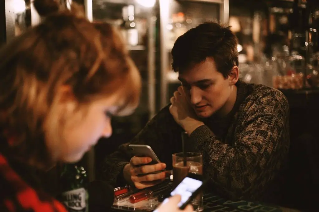 A man and woman looking at their phones - how a girl feels when you block her 